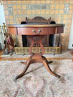 Full front view showing oval table, harp pedestal, claw feet, drawer