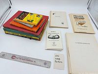 All eleven items laid out showing bound volumes, loose-page booklets and size reference