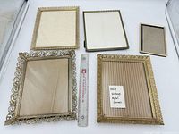 Group shot of all five gold-tone metal frames with ruler for scale