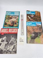 Group shot of all four magazines with ruler for scale