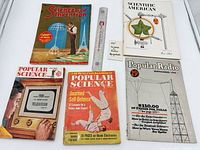 Group shot of all five magazines and scale ruler
