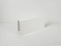 Full view of white triangular metal candle holder showing four tealight openings