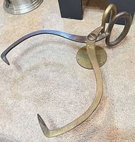 Oblique view showing full tongs, curved arms, pivot joint, mounting plate