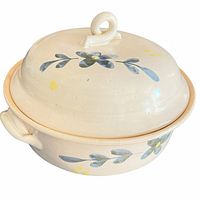 Front angle of ceramic pot with lid showing floral design and side handle