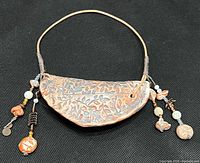 Full view of necklace showing ceramic pendant, cord and bead dangles