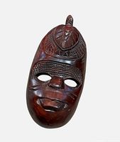 Front view of entire carved wooden mask showing overall design and finish