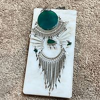 Full view of necklace showing green cabochon, filigree collar and fringe