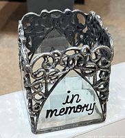 Front view showing metal filigree, glass, and “in memory” text