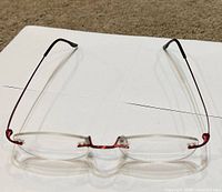 Front view of rimless red metal eyeglass frames