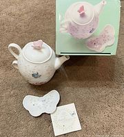 Teapot, butterfly dish, booklet and box displayed