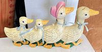 Left side view of four connected duck figurines