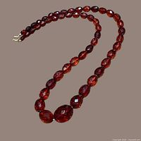 Necklace coiled to display bead facets and clasp