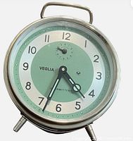 Front view showing full clock face, hands, numerals, twin-bell design