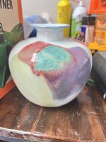 Front view of bulbous porcelain vase showing multicolor drip-glaze pattern
