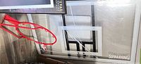 Front view of clear acrylic backboard with red rim placed beside it
