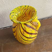 Side view of vase showing swirl pattern, flared rim, and side nub
