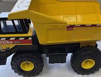 Side view of Tonka dump truck showing full item and overall condition
