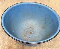 Overall view of blue enamelware bowl showing interior wear and rust