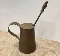 Side view of brass fire starter pot with wand inserted