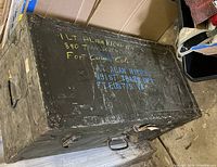 Full view of olive drab military trunk with stenciled markings