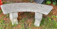 Entire curved stone bench on grass