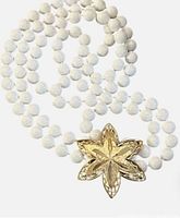 Coiled view of necklace showing white beads and gold-tone slide clasp