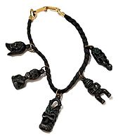 Entire bracelet showing cord, five tiki charms, and clasp