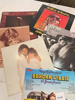 All six album jackets laid out, partial overlap; visible titles for Stevie Wonder, A-ha, Streisand Guilty, unidentified LP, A Star Is Born, and Boxcar Willie.