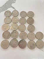 Overhead view of 22 Canadian 50-cent coins laid out obverse up