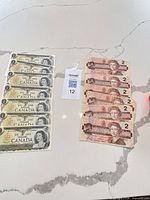 Overview of seven $1 notes and six $2 notes laid flat