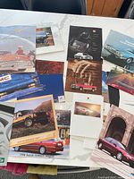 Spread view of multiple automotive brochures on table