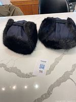 Both fur-trimmed winter hats displayed top view