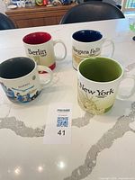 Group shot of four Starbucks city mugs Berlin Quebec New York Niagara Falls
