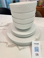 Stack of bowls, side plates and dinner plates showing pattern and quantity