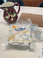 Full lot showing pitcher, sealed bag of tealights, four holders, glass frame