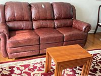 Front view of leather sofa, nesting tables and portion of rug