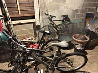 Overview of three bicycles in basement showing frames, tires and accessories