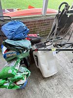 Overall view showing mower, spreader, tarps, fertilizer bags