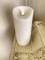 Full view of white flameless pillar candle with simulated flame