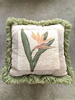 Front view of cushion showing floral motif and fringe