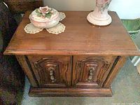 Angled top view of one night table showing wood finish and decorative pulls