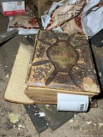 Top view of thick Holy Bible showing worn embossed cover and broken corner