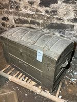 Front and top view of humpback trunk showing initials and metal hardware
