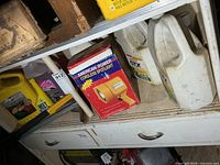 Shelf with boxed cordless spotlight, Castrol oil jug, additional jugs