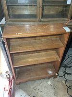 Front view of bookshelf showing three shelves and wear on top