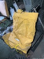 Folded yellow wax-coated canvas tarp lying on vehicle, showing texture and overall form