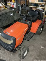Left front perspective showing full tractor body, seat, steering wheel, hood and tires