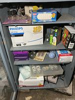 Cabinet shelves containing multiple boxed and loose light bulbs