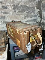 Overall view of wooden crate showing decals and strap