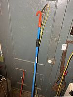 Full view of extendable pole pruner leaning against door